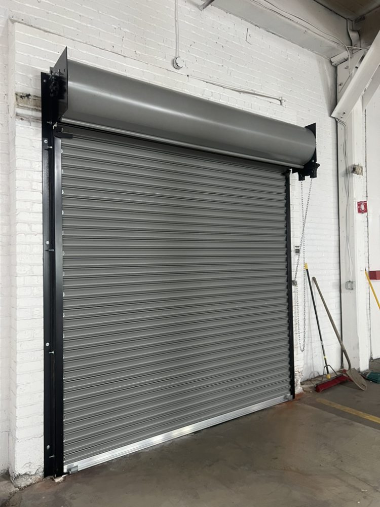 Gray rolling steel commercial door installed inside a warehouse